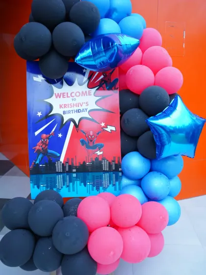 "Welcome to Krishiv's Birthday!" This comic-book style welcome sign and balloon arrangement sets an exciting tone for a Spider-Man party.