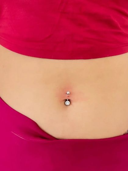 A fresh navel piercing with a jeweled barbell, showing minimal redness. My technique is designed to be as gentle as possible on the skin.