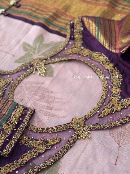 A purple blouse with a sheer back panel and heavy gold embroidery.
