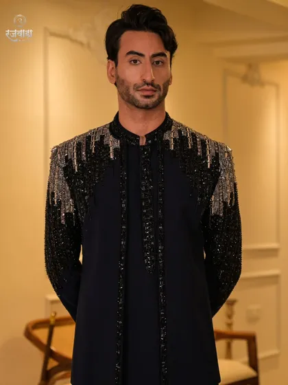 This pose highlights the sharp tailoring and structured shoulders of the black sequined jacket. It is a modern interpretation of royal armor, crafted for a celebration.
