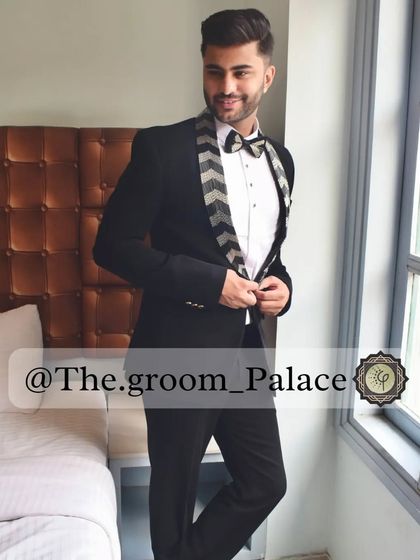 A client looking stylish in our black tuxedo with a chevron-patterned lapel and bow tie. It's a modern twist on a classic, perfect for making a subtle statement.