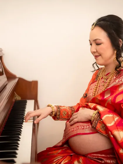 Fusing cultures and passions, this mom-to-be plays a lullaby on her piano while dressed in a traditional Indian saree, creating a deeply personal and unique portrait.