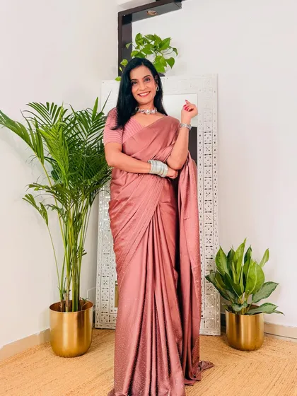 A soft, dusty pink satin saree that is both subtle and glamorous. The fabric has a lovely sheen, and it's a versatile piece for daytime or evening events.