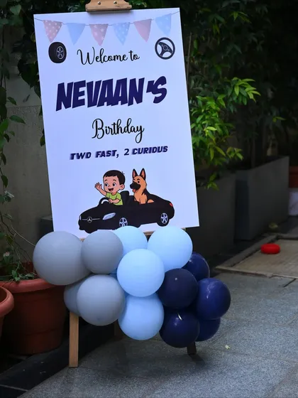 A welcome sign for the "Two Fast, 2 Curious" birthday party, featuring custom graphics that match the car theme.