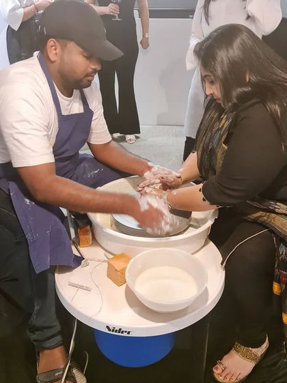 An instructor provides hands-on assistance to a participant on the pottery wheel during our special event. We ensure everyone gets the guidance they need to create their piece.