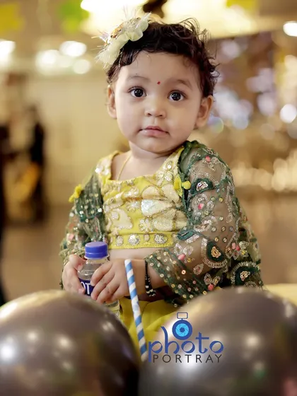 A curious portrait of the birthday girl, looking directly at the camera with her big, expressive eyes.