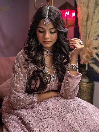 A downward-looking pose that beautifully showcases the model's eye makeup and hairstyle. This angle is great for highlighting detailed eyeshadow work and hair styling.