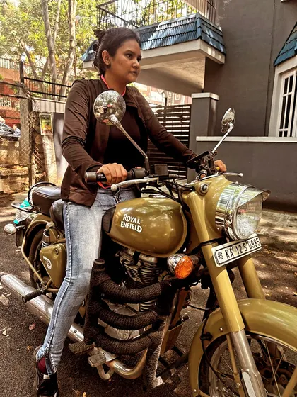 A graduate sits on her bike, looking confident and ready. She has mastered the machine and is in full control.