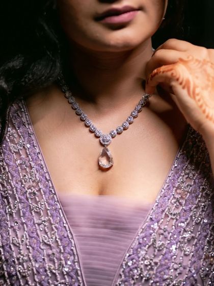 A close up shot focusing on the bride's diamond necklace, a key detail of her engagement look.