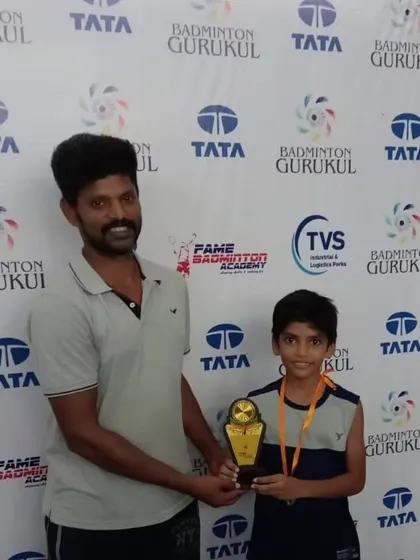A coach awards a trophy to a young boy, highlighting the supportive coach-student relationship we foster.
