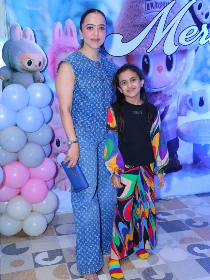 Mother and daughter pose in front of the Labubu backdrop. The detailed character art makes for a fantastic photo opportunity.