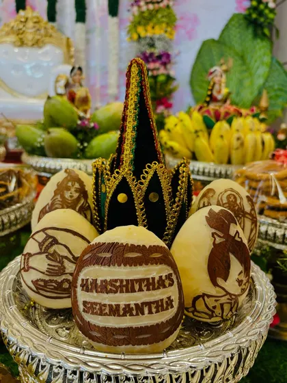 Another example of my personalized coconut carving service. This piece, for 'Harshitha's Seemantha', is surrounded by other coconuts carved with traditional motifs, making the pooja items themselves a work of art.