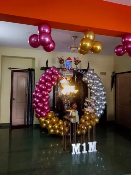A fun and colorful home birthday decoration. The circular balloon arch uses a split-color design with chrome pink and gold on one side and silver on the other, creating a unique and playful look.
