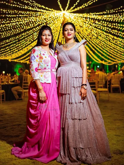 Sisters celebrating together. Our bride in her rose gold gown and her sister in the pink gown with a floral jacket, both custom-designed for the occasion.
