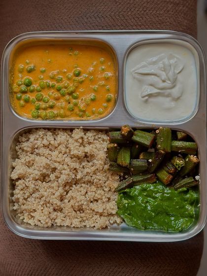 A vegetarian high-protein meal to boost immunity. It features quinoa, green peas curry, Greek yogurt, and sautéed okra with spinach, providing a powerhouse of nutrients.