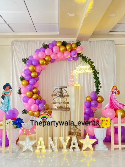 A lovely princess theme with light-up stars and a personalized name sign. The mix of purple, pink, and gold balloons creates a warm and inviting atmosphere for the party.