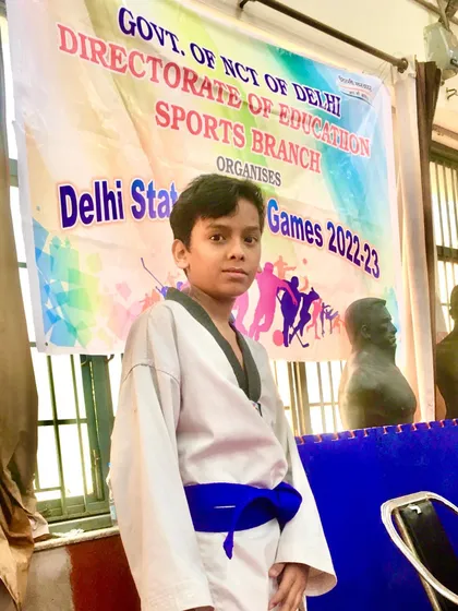 Raj proudly displays his silver medal from the Delhi State School Games 2022-23, a hard-fought achievement.