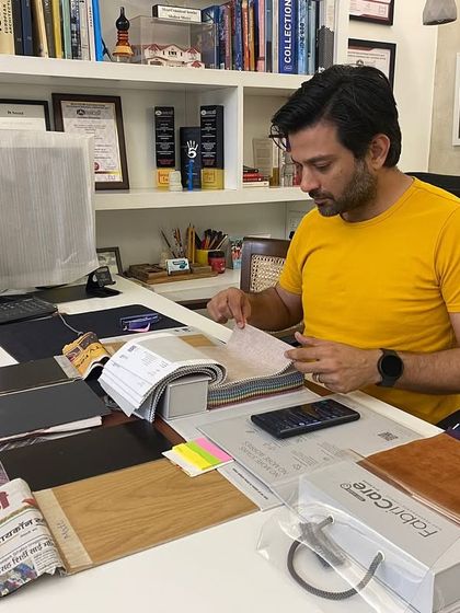 Another shot from a typical workday, surrounded by fabric swatches, wood samples, and design books. The details are everything.