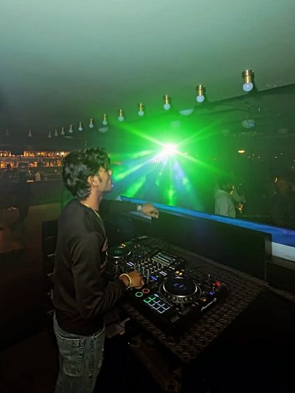 A view from my console, looking out at the dance floor under a web of green laser lights. This is the immersive experience I create.