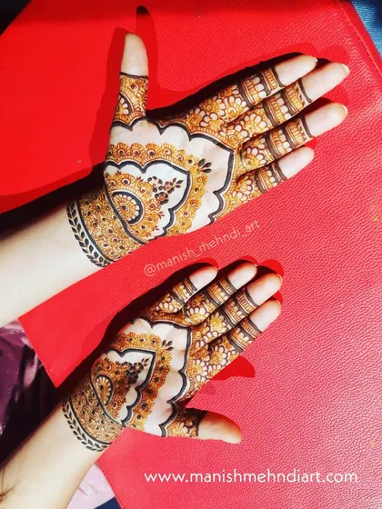 A beautiful example of how different patterns can work together. The back of the hands feature a large paisley motif, a classic element in Indian mehndi.