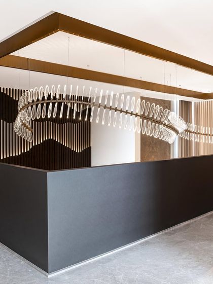 The full view of the chandelier shows its unique, spine-like form, which elegantly spans the double-height void above the staircase. It is a perfect example of how we use bespoke lighting to elevate a space.