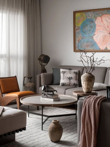 The living room is a calm and sophisticated space, with a neutral color palette, soft textiles, and a large abstract painting that adds a splash of color.