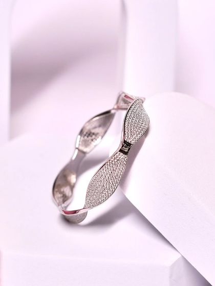 Adorn your wrist with elegance. This timeless silver bangle with a sparkling bow design is a beautiful and sophisticated piece.