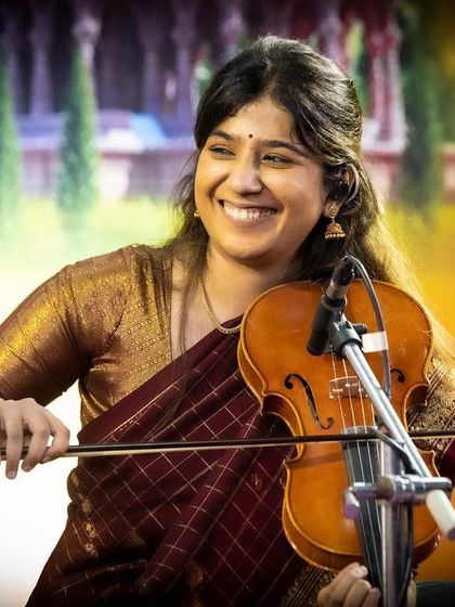 A beautiful, smiling shot of Apoorva Krishna during a traditional concert. Her joy in playing is contagious.