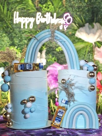 Double the trouble, double the cake. This unique split cake was designed for twins, featuring a blue rainbow theme with miniature liquor bottles for the adults to enjoy.