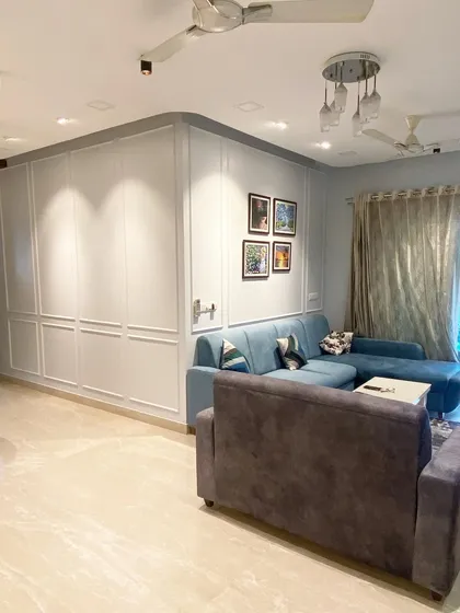 Here you can see how I use custom paneling to conceal storage and create a seamless, elegant wall feature. This not only adds a decorative element but also maximizes functionality in the living area without adding visual clutter.