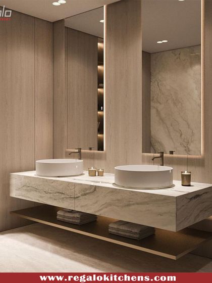 This floating vanity with dual vessel sinks has a beautiful, textured marble top. The wall-to-wall mirror and integrated shelving make the space feel open and organized.