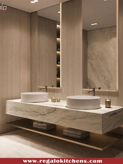 This floating vanity with dual vessel sinks has a beautiful, textured marble top. The wall-to-wall mirror and integrated shelving make the space feel open and organized.