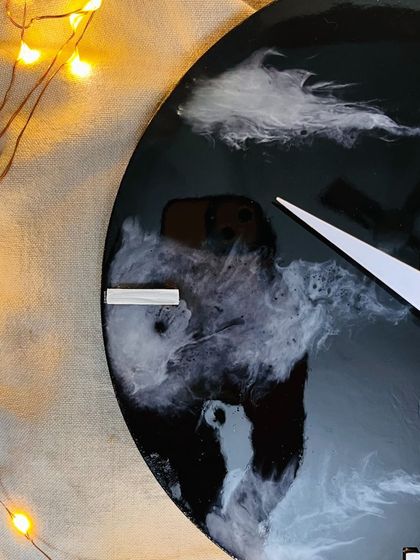 A close-up of a finished galaxy resin clock, with fairy lights adding a magical glow. This shows the beautiful decor you can create.