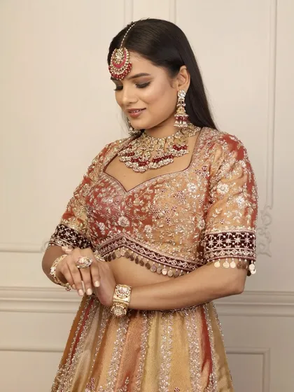 Admiring the complete 'Riwayat' ensemble. The makeup is designed to complement the intricate details of the bridal outfit and jewelry, creating a cohesive and stunning phera look.