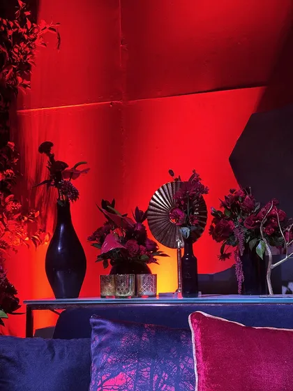 A console table styled with dark vases and sculptural floral elements, showcasing a moody and artistic approach to decor details.