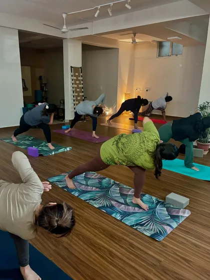 Students moving through Parivrtta Trikonasana (revolved triangle pose). This challenging twist improves balance, aids digestion, and strengthens the legs.
