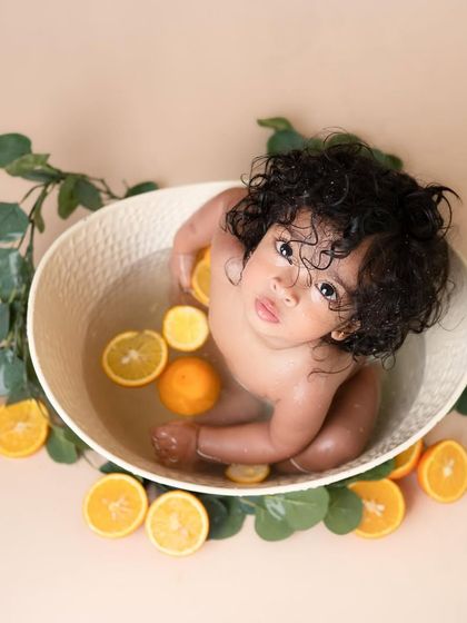 A beautiful overhead shot of our fruit bath session. This little one with the gorgeous curls looks so serene and curious surrounded by oranges in the water.