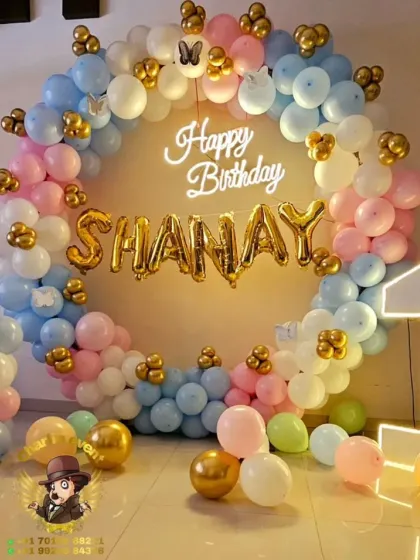 A pastel-themed first birthday with a balloon ring, a "1" marquee number, and the name "SHANAY" in foil balloons.