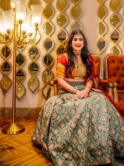 A regal portrait of the bride seated in a classic armchair. The combination of the elegant decor, the beautiful lehenga, and her confident smile makes for a truly royal shot.