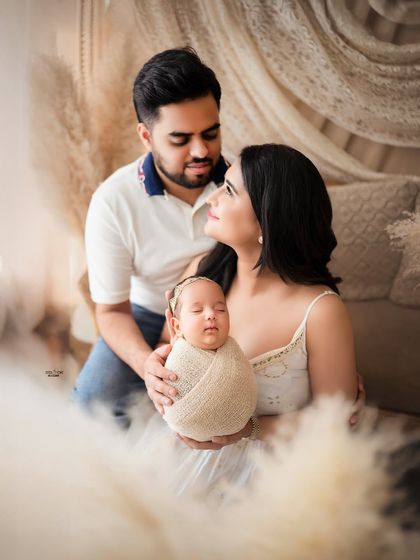 New parents admiring their sleeping baby. The beginning of their beautiful journey as a family, captured forever.