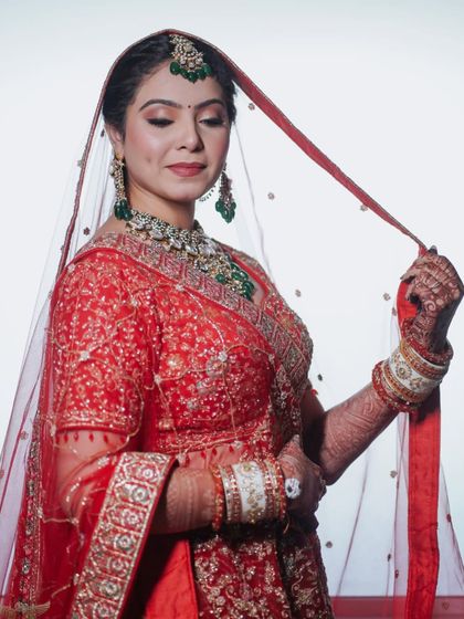 A beautiful shot of the bride in her red lehenga, with her mother by her side. The makeup is elegant and timeless, perfect for these cherished family moments.