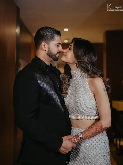 An intimate portrait of the couple at their reception. Their coordinated black and silver outfits exude modern elegance and style.