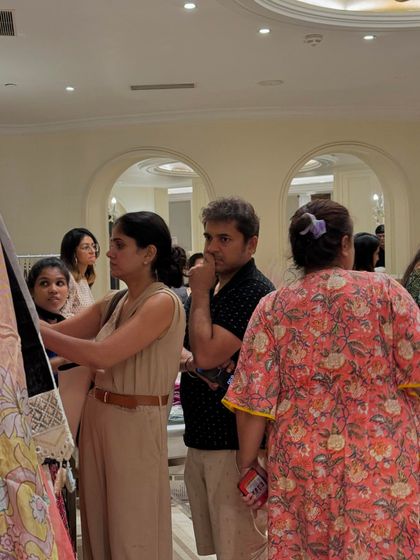 A potential customer carefully inspects the fabric of a garment, showing the kind of serious buyer my events attract.