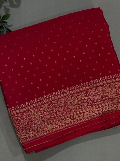 A classic red Banarasi crepe saree with a delicate buti pattern and an intricately woven border.