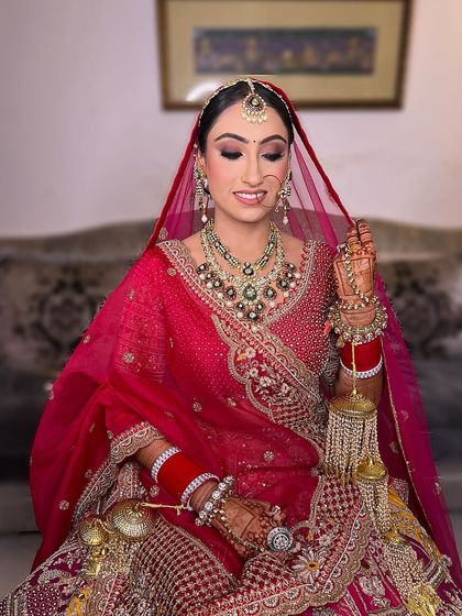 A traditional yet modern take for the wedding day. This bride's look features sparkling eyes and a radiant complexion that perfectly complements her beautiful red lehenga and heavy jewellery.