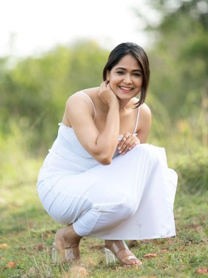 A full-length shot in a simple white dress, showing a confident and comfortable stance.