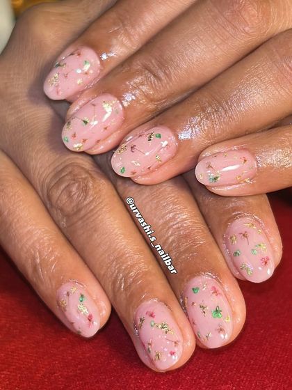 This design uses real dried flowers encapsulated in a blush-toned gel overlay with flecks of gold foil. It's a beautiful way to wear a piece of nature on your nails. The video shows a bit of the process.