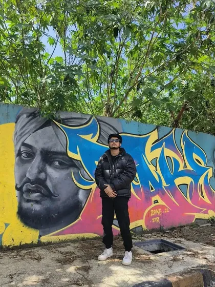 A powerful mural combining a portrait of the late Punjabi artist Sidhu Moosewala with vibrant graffiti lettering. This piece in the Marol Art Village shows the cross-cultural influence of music on Mumbai's street art.