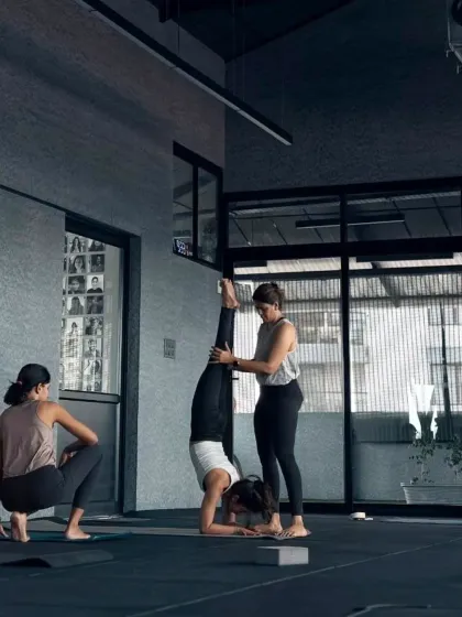In my advanced workshops, we explore what the body is capable of with focus and safe guidance. Here, I'm assisting a student with her Pincha Mayurasana alignment. These sessions are about building the strength and confidence to safely go upside down.