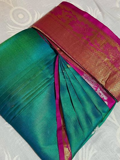 A beautiful peacock green and pink silk saree. The pleats are set, making it easy to drape and manage.